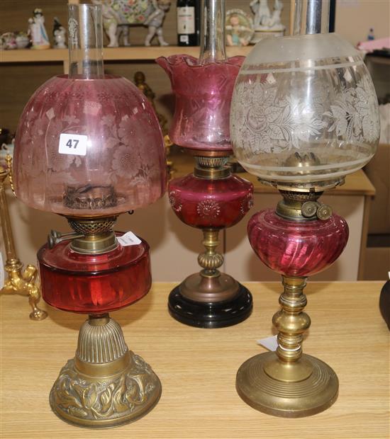 Three oil lamps with ruby glass reservoirs